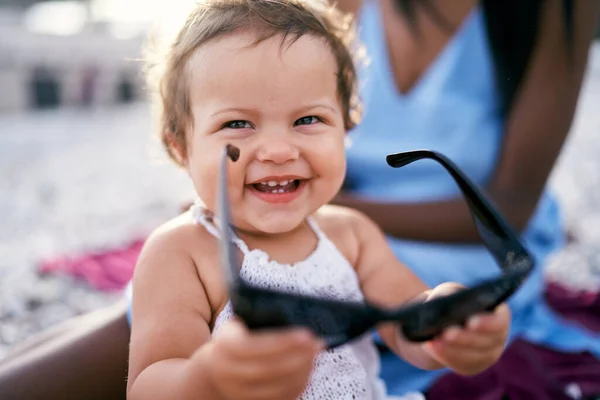 큰 선글라스를 손에 들고 웃고 있는 어린 소녀 — 스톡 사진