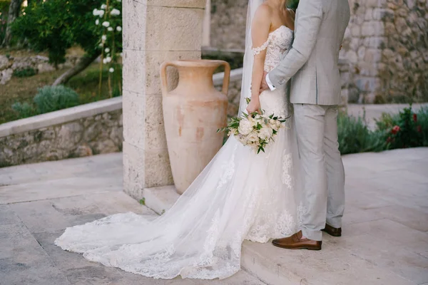 Mariée et marié avec un stand de bouquet près d'une belle arche en pierre — Photo