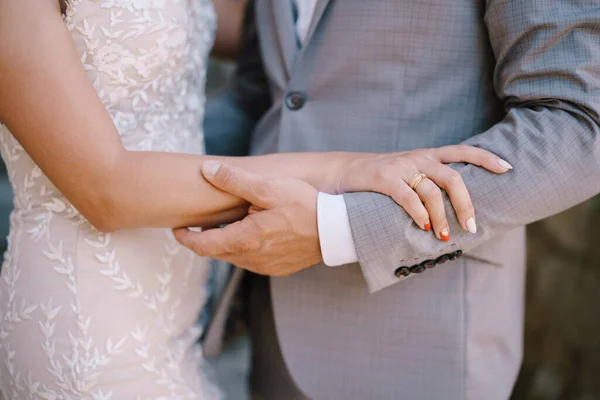 Lo sposo tiene il braccio della sposa. Primo piano — Foto Stock