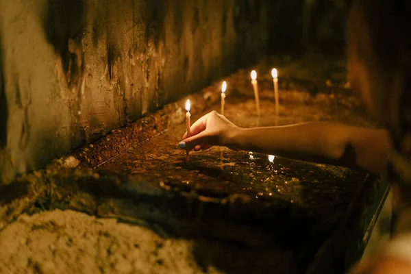 女人把点燃的蜡烛放在烛台上 — 图库照片