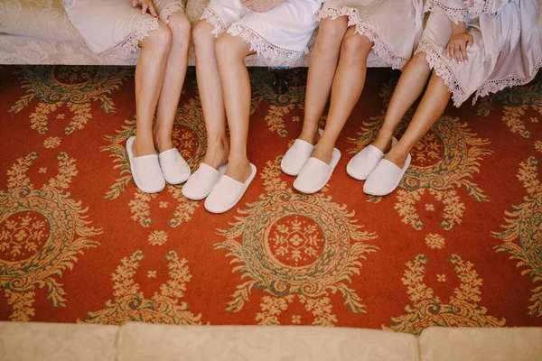 Piernas de damas de honor en albornoces y zapatillas — Foto de Stock