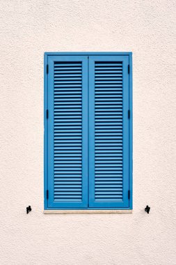 Evin duvarında mavi panjurlu pencere. Yakın plan.