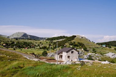 Yol kenarındaki bir dağ köyünde ağaçların, otların ve yeşilliklerin arasında.