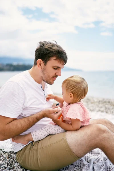 Ayah memegang seorang gadis kecil dengan batu di tangannya — Stok Foto