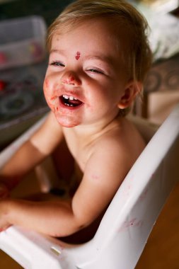 Kirli yüzlü, gülen küçük bir çocuk. Yukarıdan görüntüle