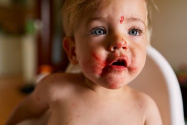 Dağınık suratlı çocuk ağzını açar. Yakın plan.