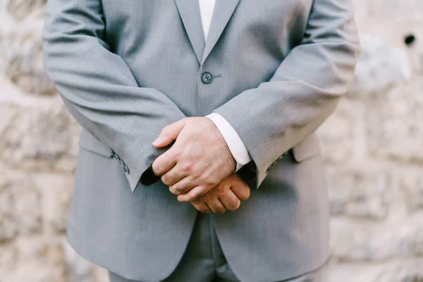 Man in a gray suit crossed his arms over his stomach. Close-up — Stock Photo, Image