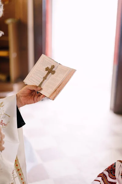 Bible and the cross in the hand of the priest. Close-up — Stock Photo, Image