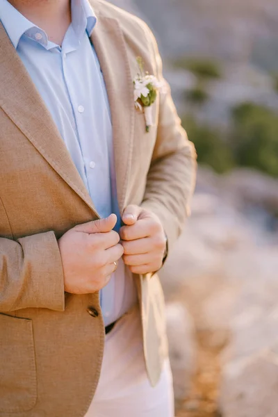 Damat ellerini ceketinin yakasında tutuyor. Yakın plan. — Stok fotoğraf