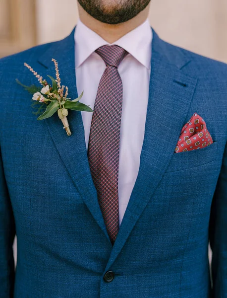 Brudgummen i en jacka med en boutonniere på kavajen och en näsduk i fickan. Närbild — Stockfoto