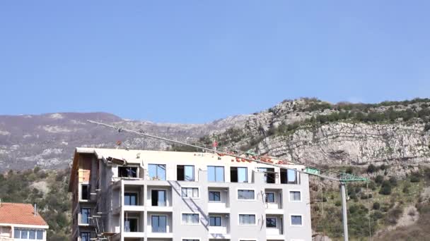 Construcción de un edificio de varios pisos al pie de las montañas — Vídeos de Stock