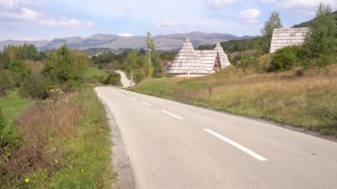 Durmitor Milli Parkı 'ndaki üç köşeli evlerin yanından geçen Paved yolu.