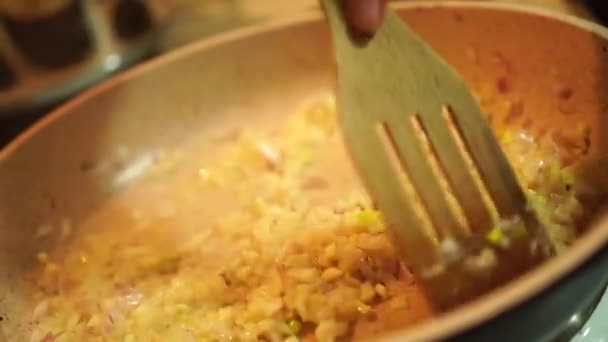 Proses memasak bawang cincang halus dalam panci dengan spatula — Stok Video