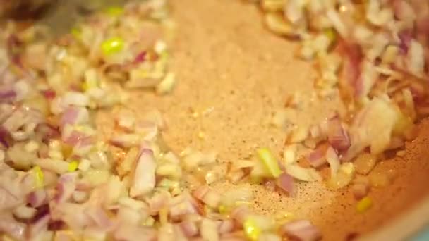 Перемішати цибулю з шпателем на сковороді під час приготування — стокове відео