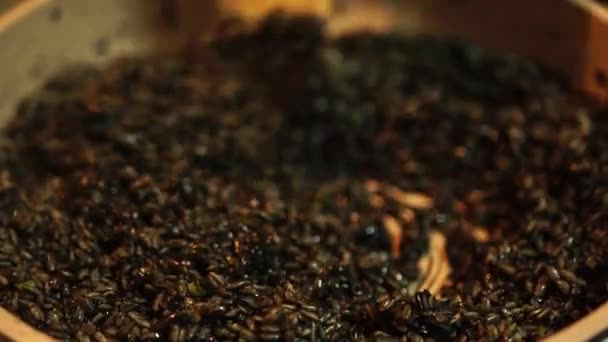 Prozess der Mischung von schwarzem Risotto mit Reis in einer heißen Pfanne — Stockvideo