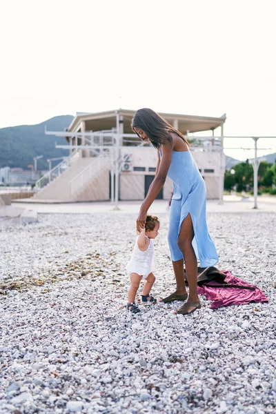 Ibu berdiri di pantai dan memegang putri kecilnya dengan tangan — Stok Foto