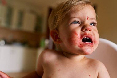 Kirli yüzlü küçük çocuk surat yapar.