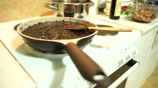 Padella con risotto nero con una spatola in cima è sul fuoco — Video Stock