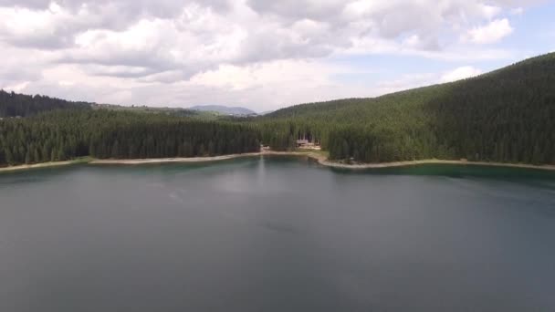 Małe domki w sosnowym lesie nad brzegiem jeziora Black Lake. Park Narodowy Durmitor — Wideo stockowe