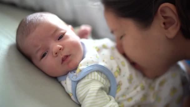 Mãe beija a barriga do bebê deitado na cama — Vídeo de Stock