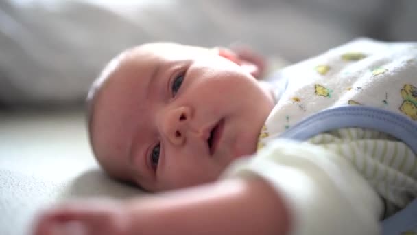 Recém-nascido está deitado na cama e se alongando — Vídeo de Stock