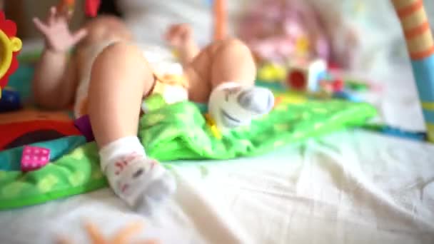 Newborn jerks feet on the play mat — Stock Video