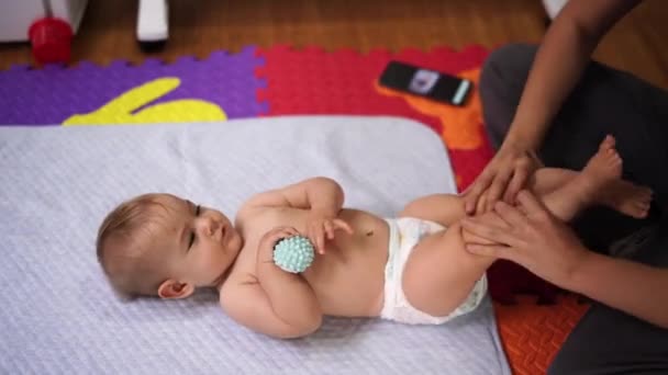 Mãe levanta e abaixa as pernas do bebê — Vídeo de Stock