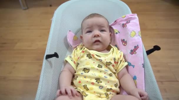 Newborn baby lies on a baby rocking chair — Stock Video