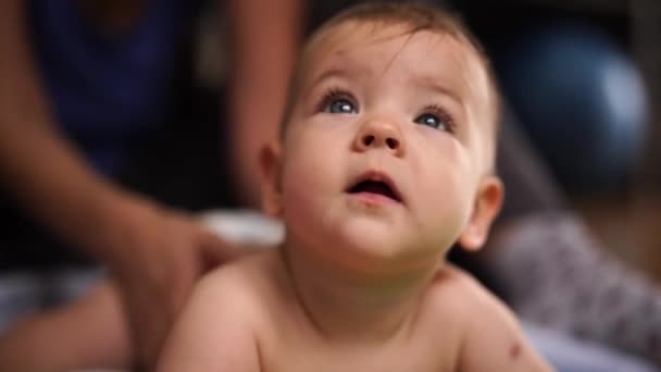 Mama masuje tył dziecka leżącego na brzuchu — Wideo stockowe