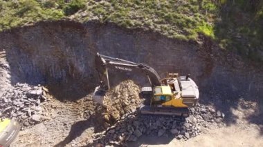 Kazıcı kovayla bir dağ kazıyor.