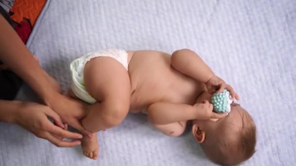 Maman tourne l'enfant sur le côté et fait des exercices avec lui — Video