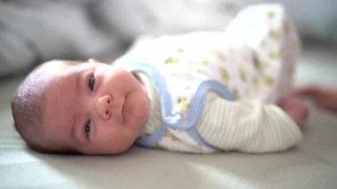 Bebek yatakta uzanıyor ve esniyor