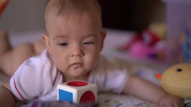 Baby liegt auf dem Bauch auf dem Bett und dreht den Kopf — Stockvideo