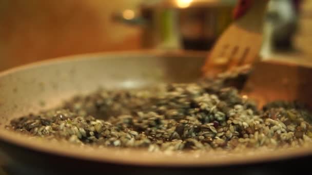 Een proces van zwarte risotto maken. Roeren van sojasaus met groenten en rijst in een pan — Stockvideo
