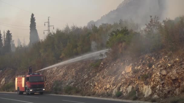 Firefighters on a fire truck extinguish a forest fire in the Montenegrin mountains — Stock Video