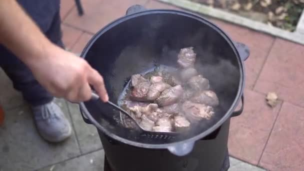 Mélanger la viande dans un chaudron pour pilaf ouzbek — Video