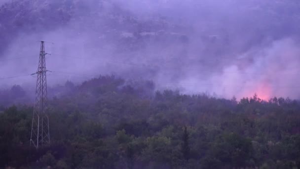 Сильний вогонь з диму в горах Чорногорії біля ліній електропередач. — стокове відео