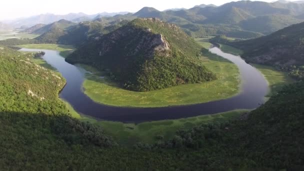Loop alakú kanyar a Crnojevica folyó körül egy zöld hegy — Stock videók