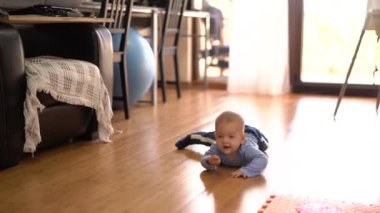 Bebek, ahşap mutfak zemininde midede sürünüyor.