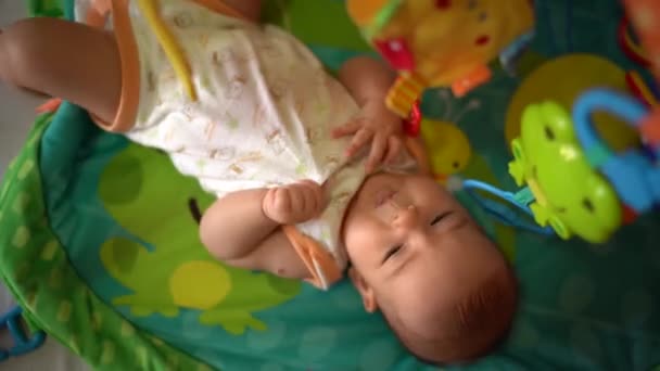 Baby 's liggen op de speelmat en trillen. Bovenaanzicht — Stockvideo