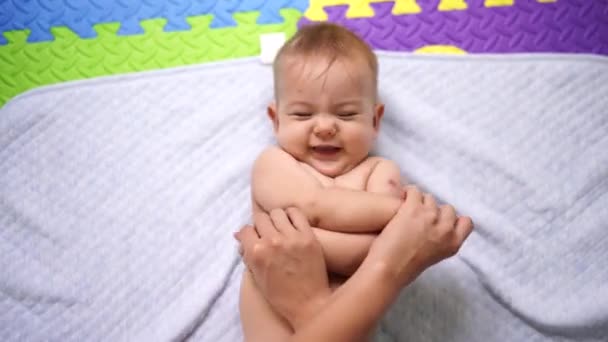 Moeder kruist de handen van de liegende baby op de buik — Stockvideo