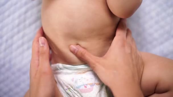 Les mains féminines massent le ventre d'un bébé — Video