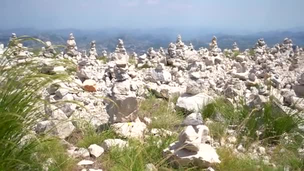 Piedras apiladas en colinas se encuentran en la cima de una montaña en el Parque Nacional Durmitor — Vídeos de Stock