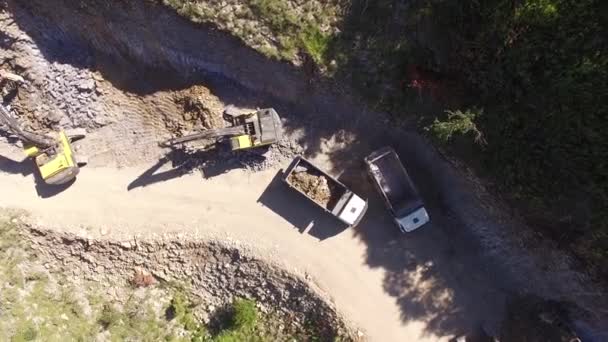 Excavatorul umple camionul cu sol. Vedere aeriană — Videoclip de stoc