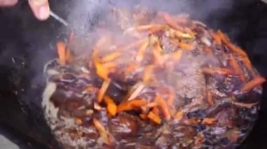 Özbek pilavında baharat, kuru üzüm, et, havuç ve soğan karışımı