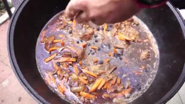 Özbek pilavı pişirirken et, havuç ve soğana kuru üzüm eklemek
