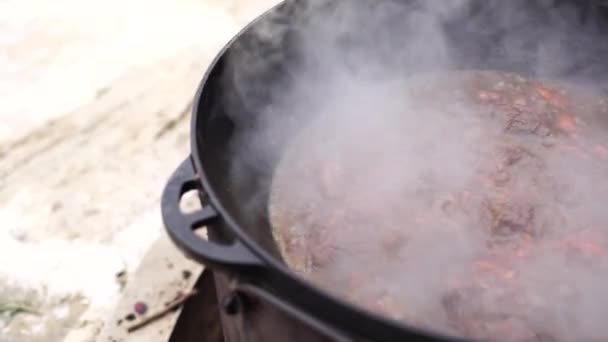Steam when cooking Uzbek pilaf in a cauldron — Stock Video