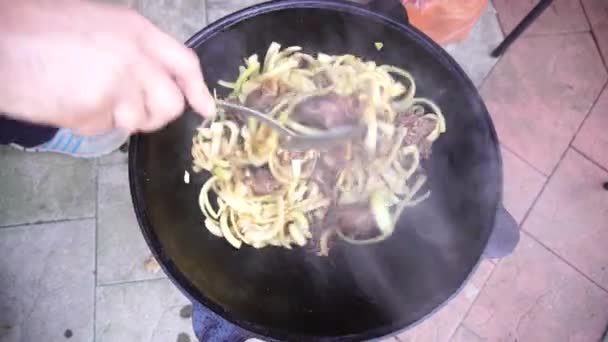 Hús keverése hagymával és fokhagymával a pilaf egy üstben — Stock videók