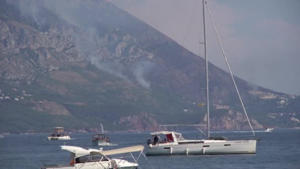 Żaglówki w morzu w dymie z pożarów lasów — Wideo stockowe