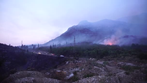 Voitures avec phares sur les lecteurs sur l'autoroute à travers la fumée d'un feu de forêt — Video